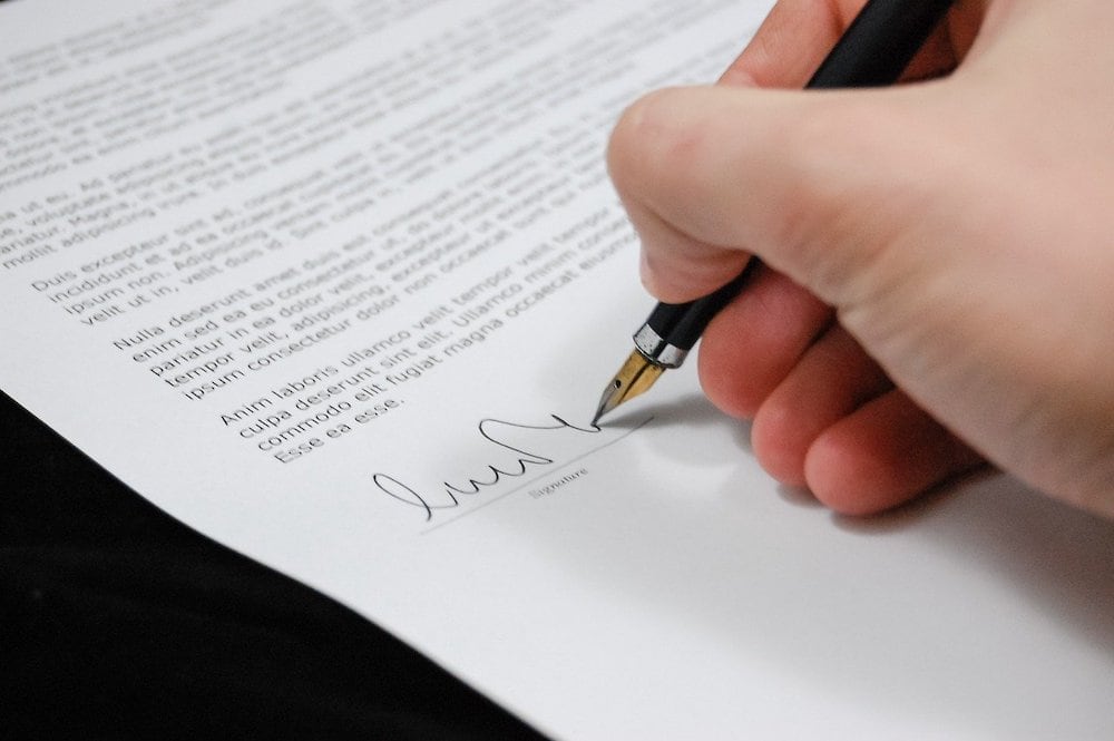 man signing document